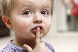 Little boy with finger on his lips.
