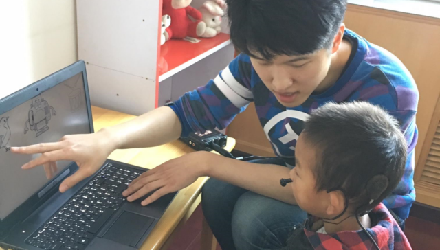 Researcher working with a child with Cochlear Implants