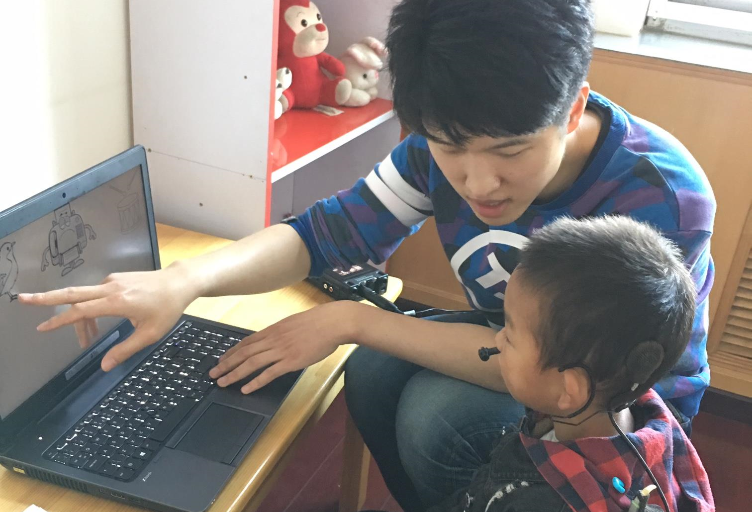Researcher working with a child with Cochlear Implants